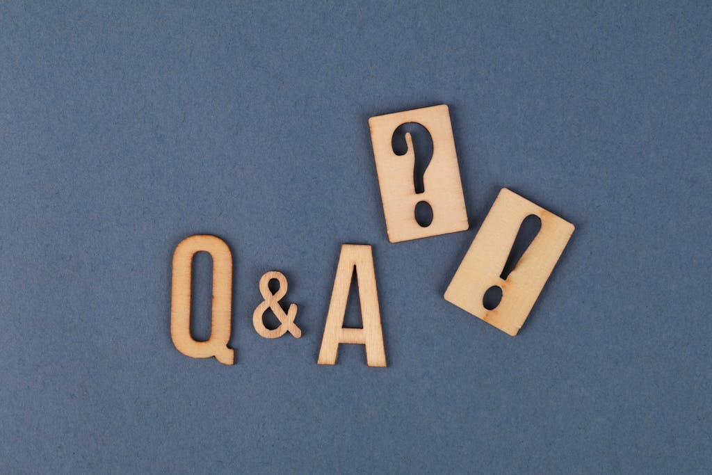 Flat lay of wooden Q&A letters with punctuation marks on a gray background.